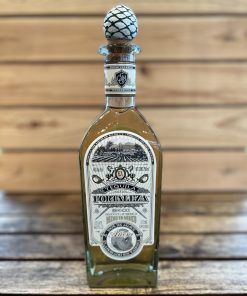 Tequila Fortaleza Añejo con fondo madera